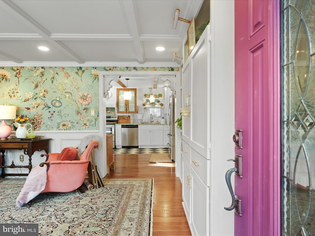 entrance foyer with wood-type flooring, sink, ornamental molding, coffered ceiling, and beam ceiling