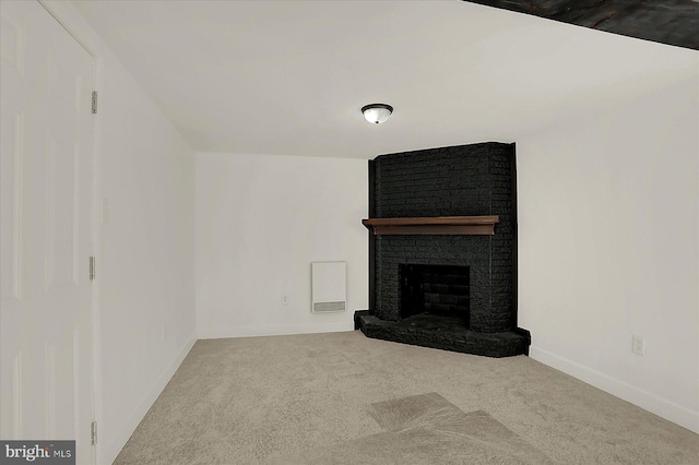 unfurnished living room featuring carpet and a brick fireplace