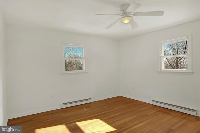 empty room with ceiling fan, a baseboard radiator, and hardwood / wood-style floors