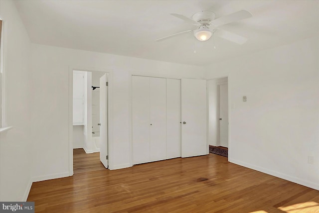 unfurnished bedroom with wood-type flooring, ceiling fan, and a closet