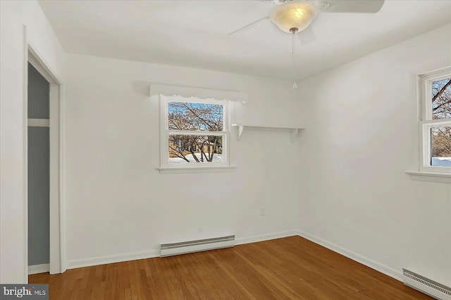 empty room with wood-type flooring, a baseboard heating unit, and ceiling fan