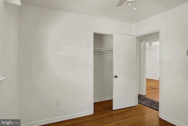 unfurnished bedroom featuring hardwood / wood-style flooring, ceiling fan, and a closet