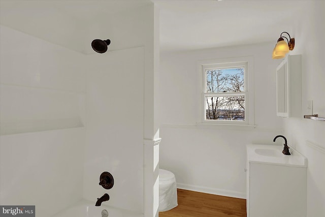 full bathroom featuring vanity, hardwood / wood-style floors, washtub / shower combination, and toilet