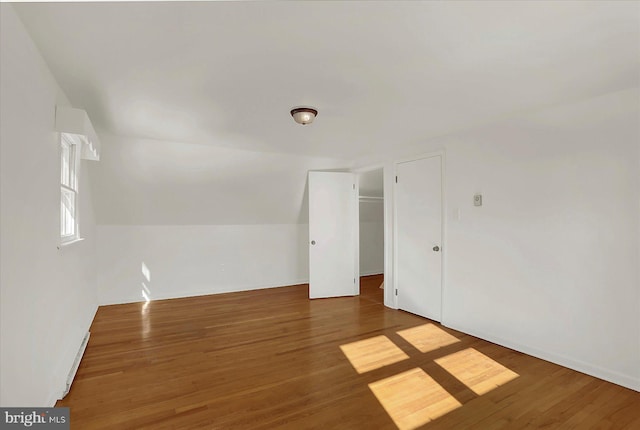 additional living space with vaulted ceiling and dark hardwood / wood-style floors