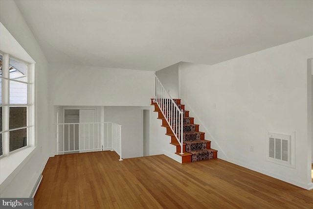 spare room with hardwood / wood-style floors, plenty of natural light, and baseboard heating