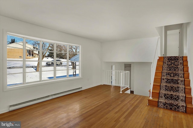 unfurnished living room with hardwood / wood-style flooring and baseboard heating