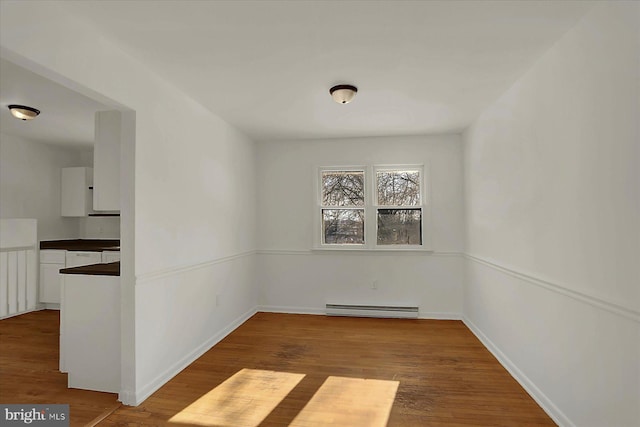 unfurnished room with a baseboard radiator and light hardwood / wood-style floors