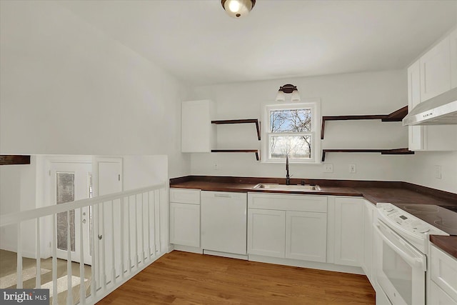 kitchen with white cabinetry, sink, white appliances, and light hardwood / wood-style flooring