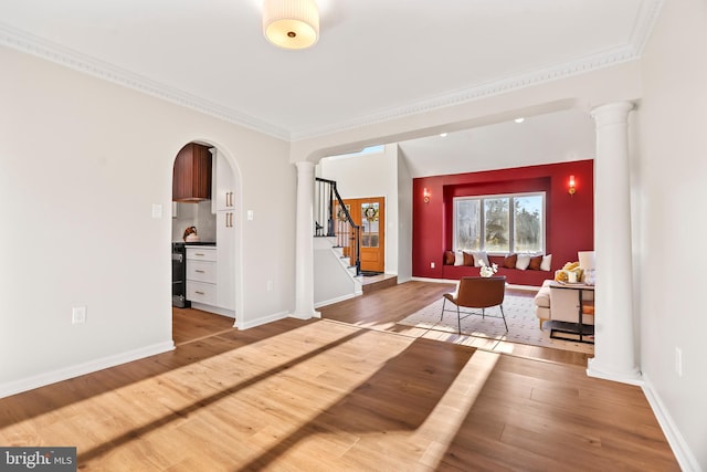 interior space with hardwood / wood-style floors, crown molding, and ornate columns