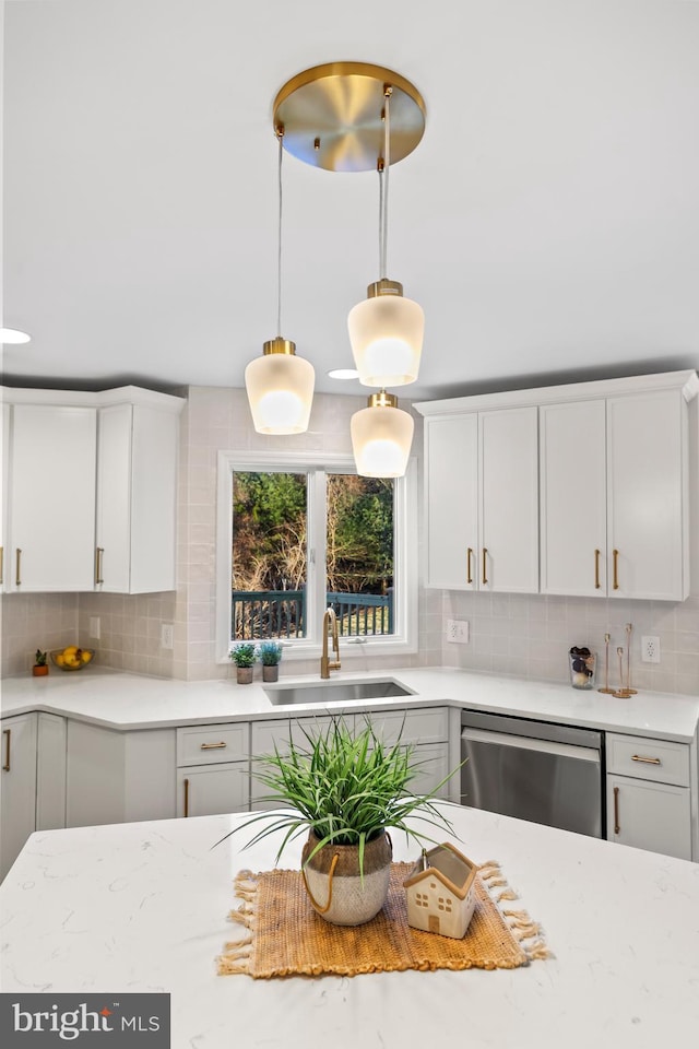 kitchen featuring sink, dishwasher, white cabinets, and decorative backsplash