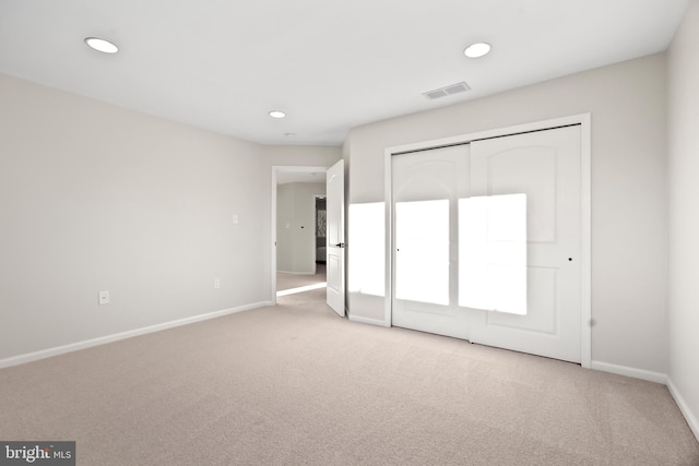 unfurnished bedroom featuring a closet and light carpet