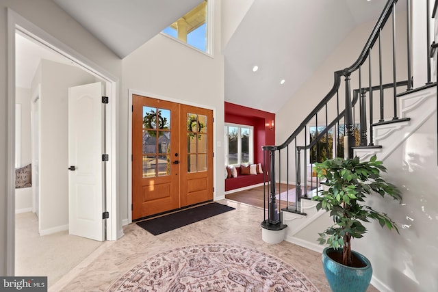 foyer entrance featuring french doors and high vaulted ceiling