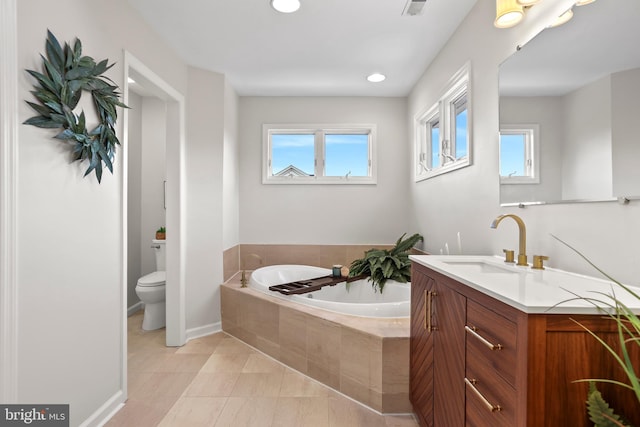 bathroom with toilet, tile patterned flooring, tiled bath, and vanity