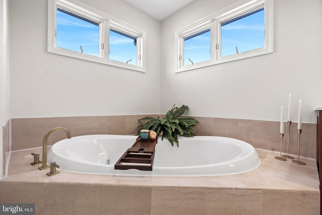 bathroom with a relaxing tiled tub