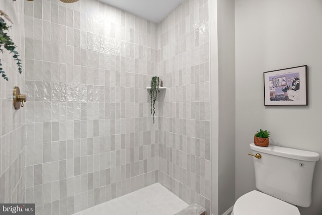 bathroom with tiled shower and toilet