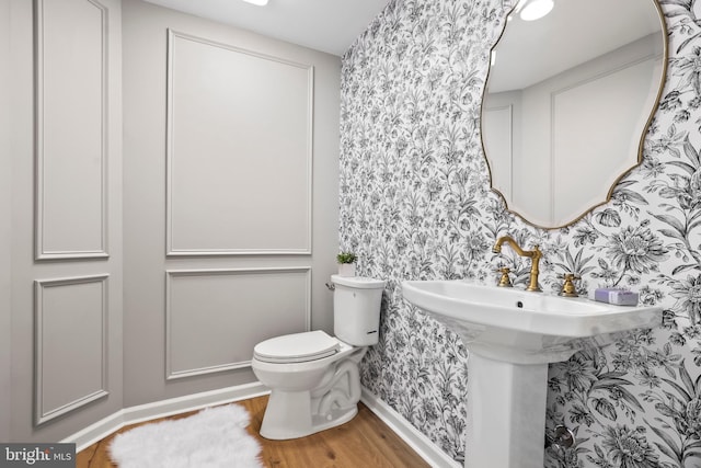 bathroom featuring toilet and wood-type flooring