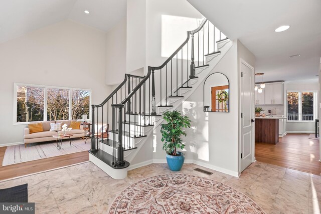 staircase featuring high vaulted ceiling