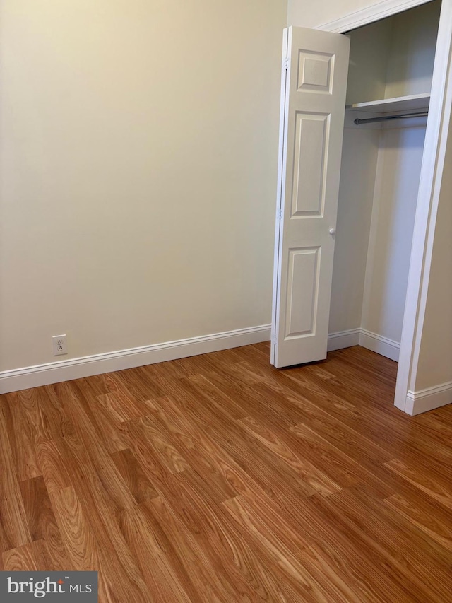 unfurnished bedroom featuring wood-type flooring and a closet