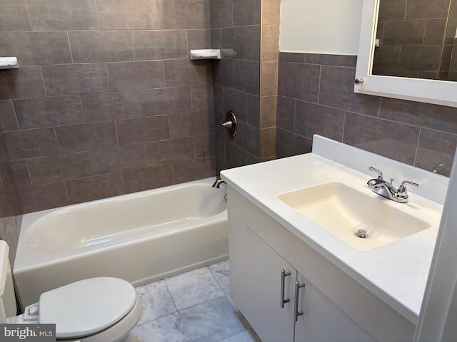 full bathroom with tile walls, toilet, vanity, and tiled shower / bath combo