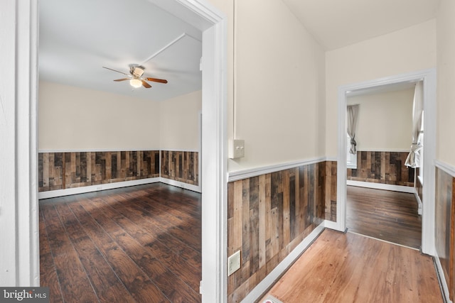 hall featuring hardwood / wood-style floors and wooden walls