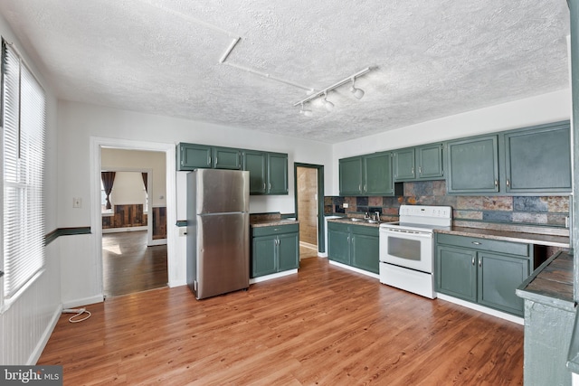 kitchen featuring green cabinetry, stainless steel fridge, light hardwood / wood-style flooring, and electric range