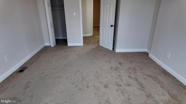 unfurnished bedroom featuring light carpet and a closet