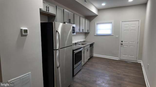 kitchen featuring stainless steel appliances, gray cabinets, sink, and dark hardwood / wood-style floors