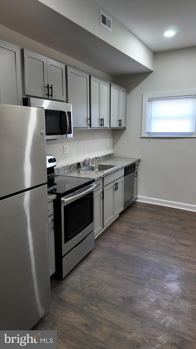 kitchen featuring dark hardwood / wood-style flooring, sink, gray cabinets, and stainless steel appliances