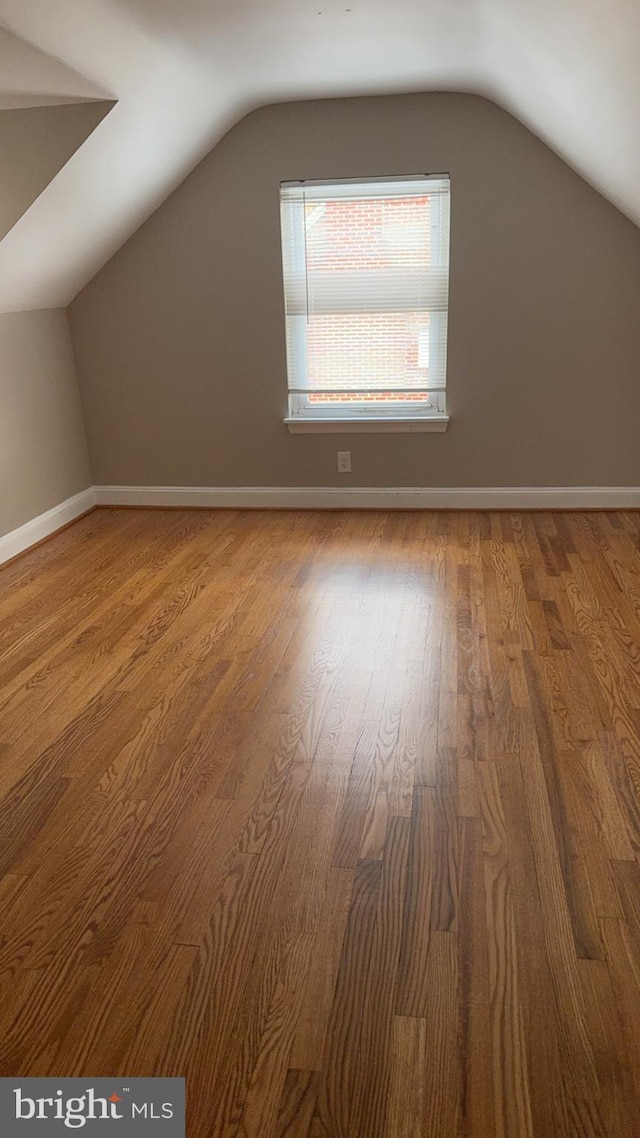 additional living space featuring vaulted ceiling and hardwood / wood-style floors