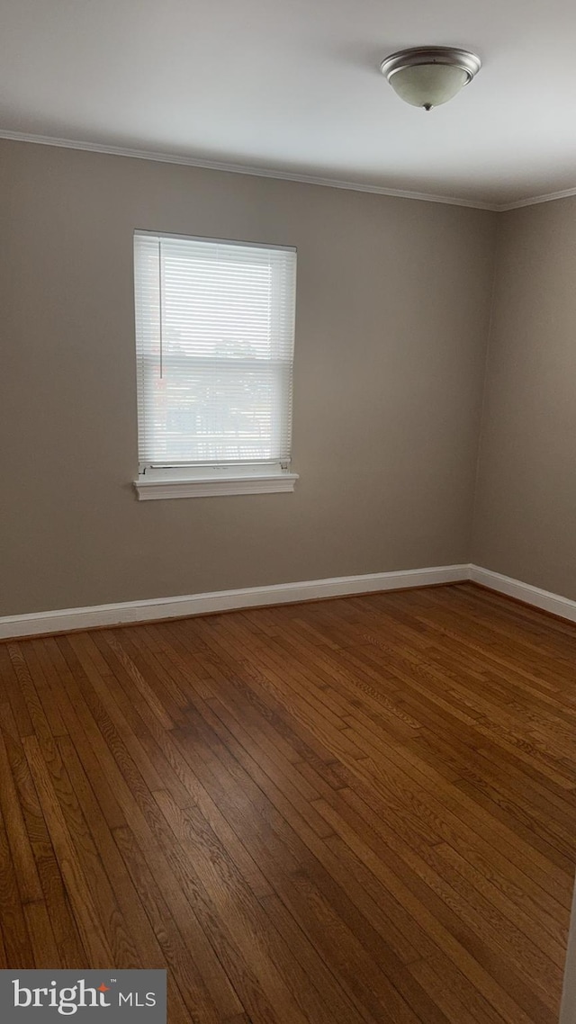 empty room featuring crown molding and hardwood / wood-style floors