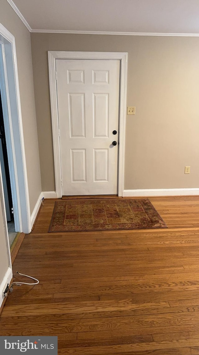 interior space featuring dark wood-type flooring and ornamental molding