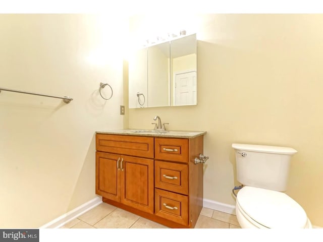 bathroom with tile patterned flooring, vanity, and toilet