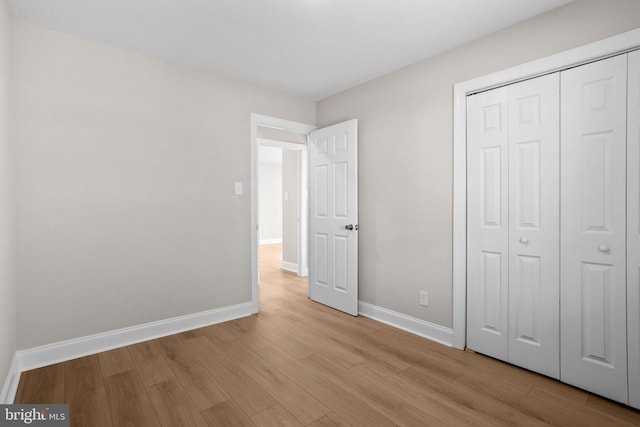 unfurnished bedroom featuring light hardwood / wood-style floors and a closet