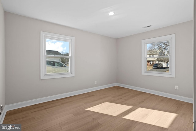 unfurnished room featuring a healthy amount of sunlight and light hardwood / wood-style floors