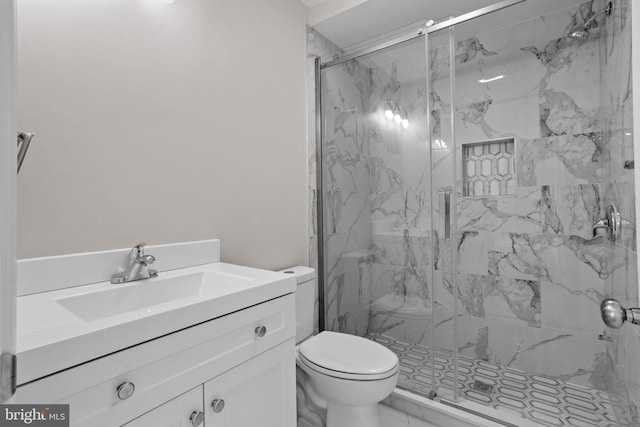 bathroom with vanity, a shower with door, and toilet