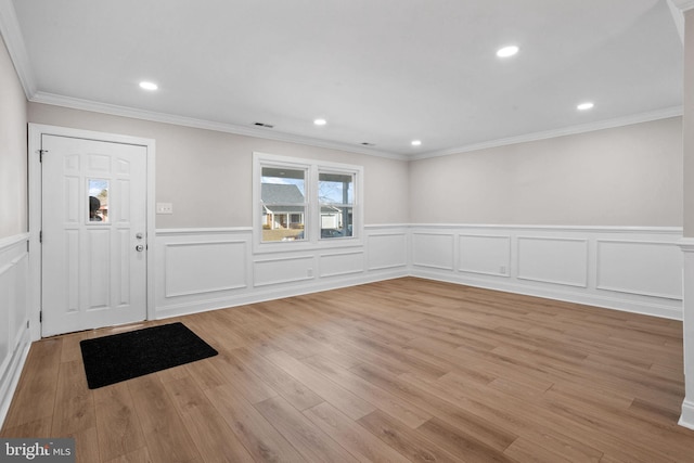 foyer entrance featuring crown molding and light hardwood / wood-style floors