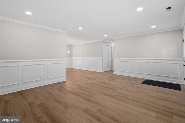 spare room with ornamental molding and light hardwood / wood-style flooring