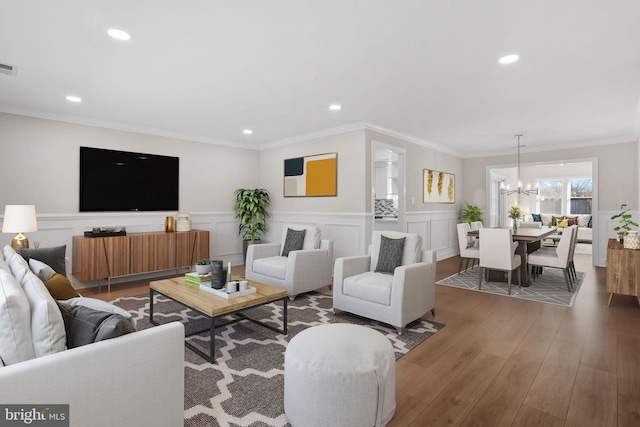 living room featuring crown molding, dark hardwood / wood-style floors, and a notable chandelier