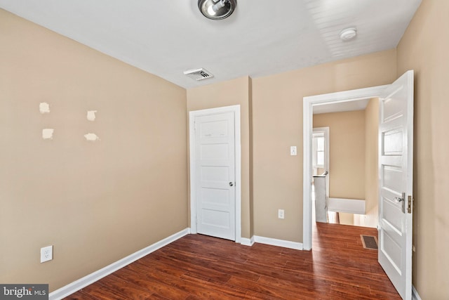 unfurnished bedroom featuring dark hardwood / wood-style flooring