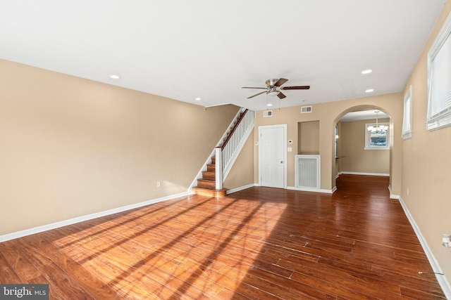 unfurnished living room featuring hardwood / wood-style flooring and ceiling fan with notable chandelier