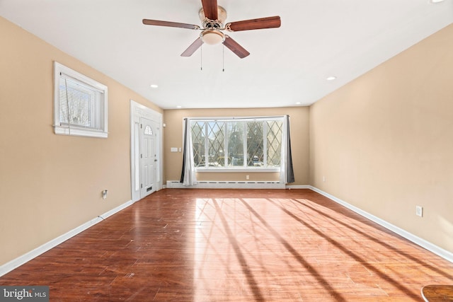 unfurnished living room featuring ceiling fan, hardwood / wood-style floors, and a baseboard heating unit