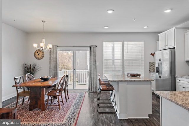 dining space with an inviting chandelier and dark wood-type flooring