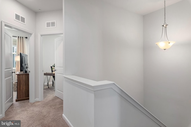 hallway featuring light colored carpet