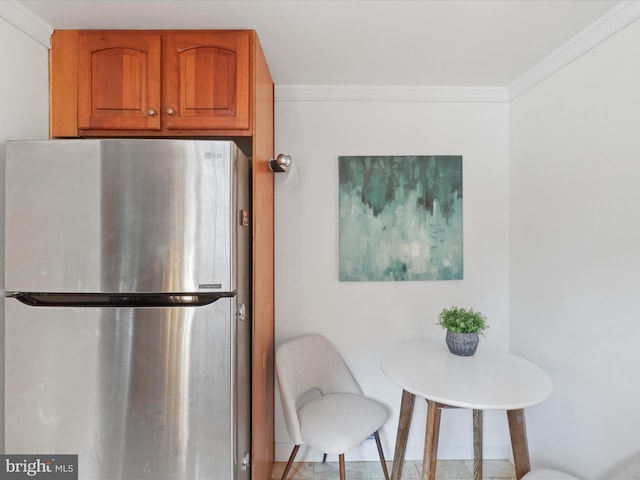 kitchen featuring stainless steel refrigerator and crown molding