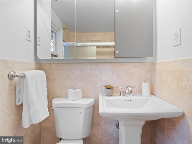 bathroom with tile walls and toilet