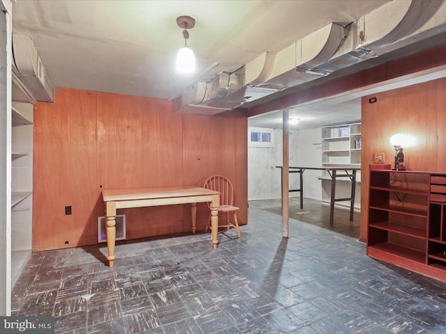 basement featuring wooden walls