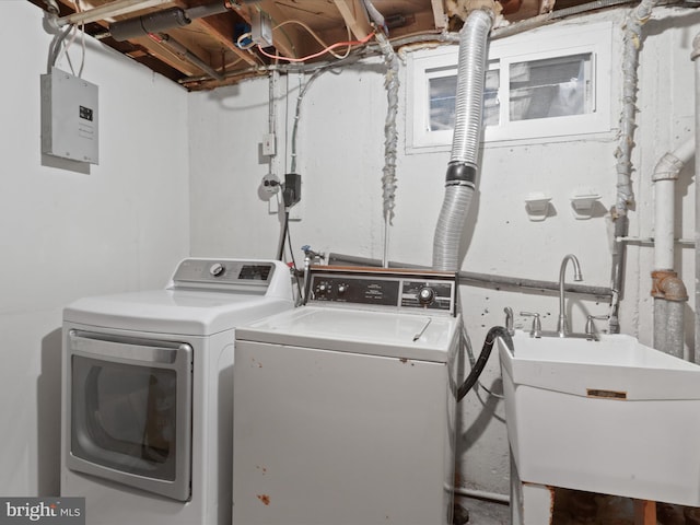 clothes washing area featuring separate washer and dryer, sink, and electric panel