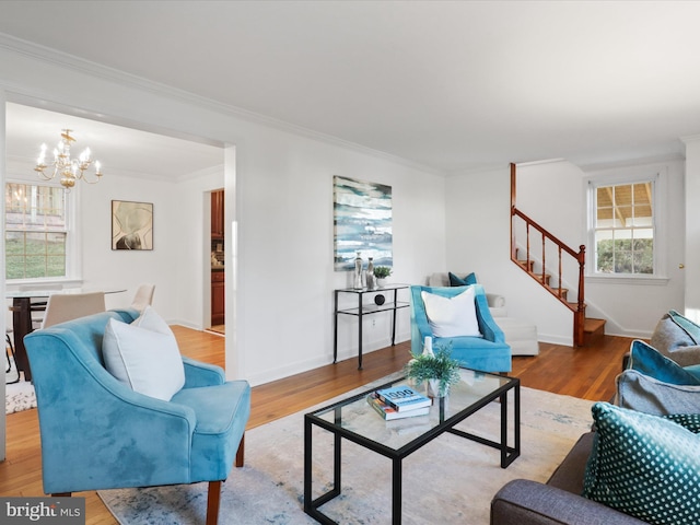 living room featuring crown molding, an inviting chandelier, and light hardwood / wood-style floors