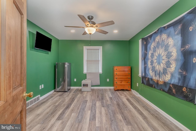 interior space featuring ceiling fan, stainless steel refrigerator, and light hardwood / wood-style floors