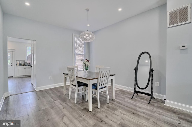 dining area featuring light wood-type flooring and an inviting chandelier